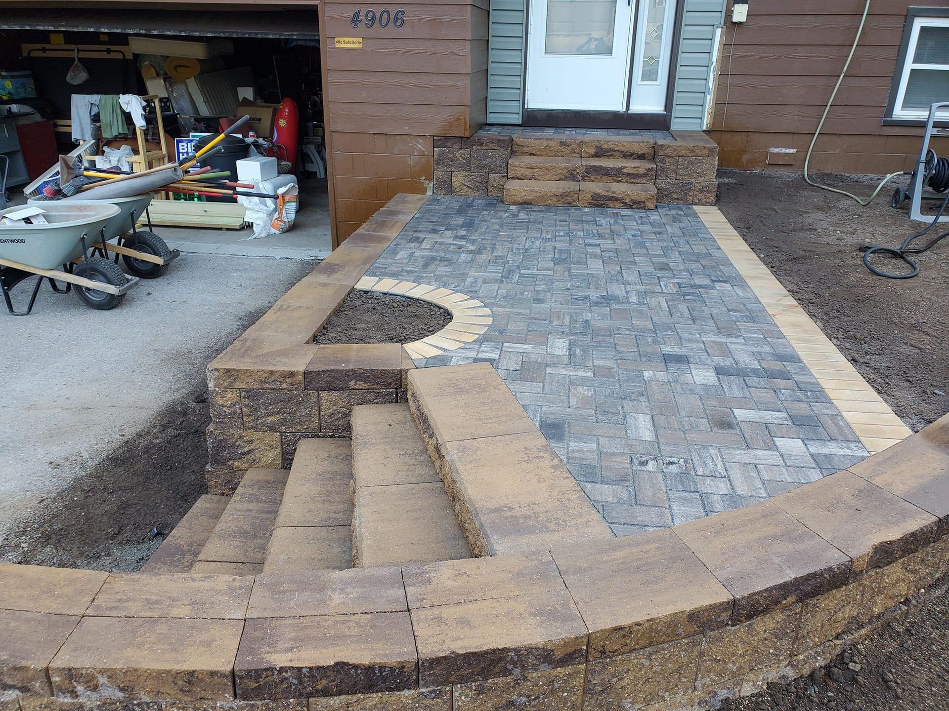 A brick walkway is being built in front of a house in Weston, Wisconsin