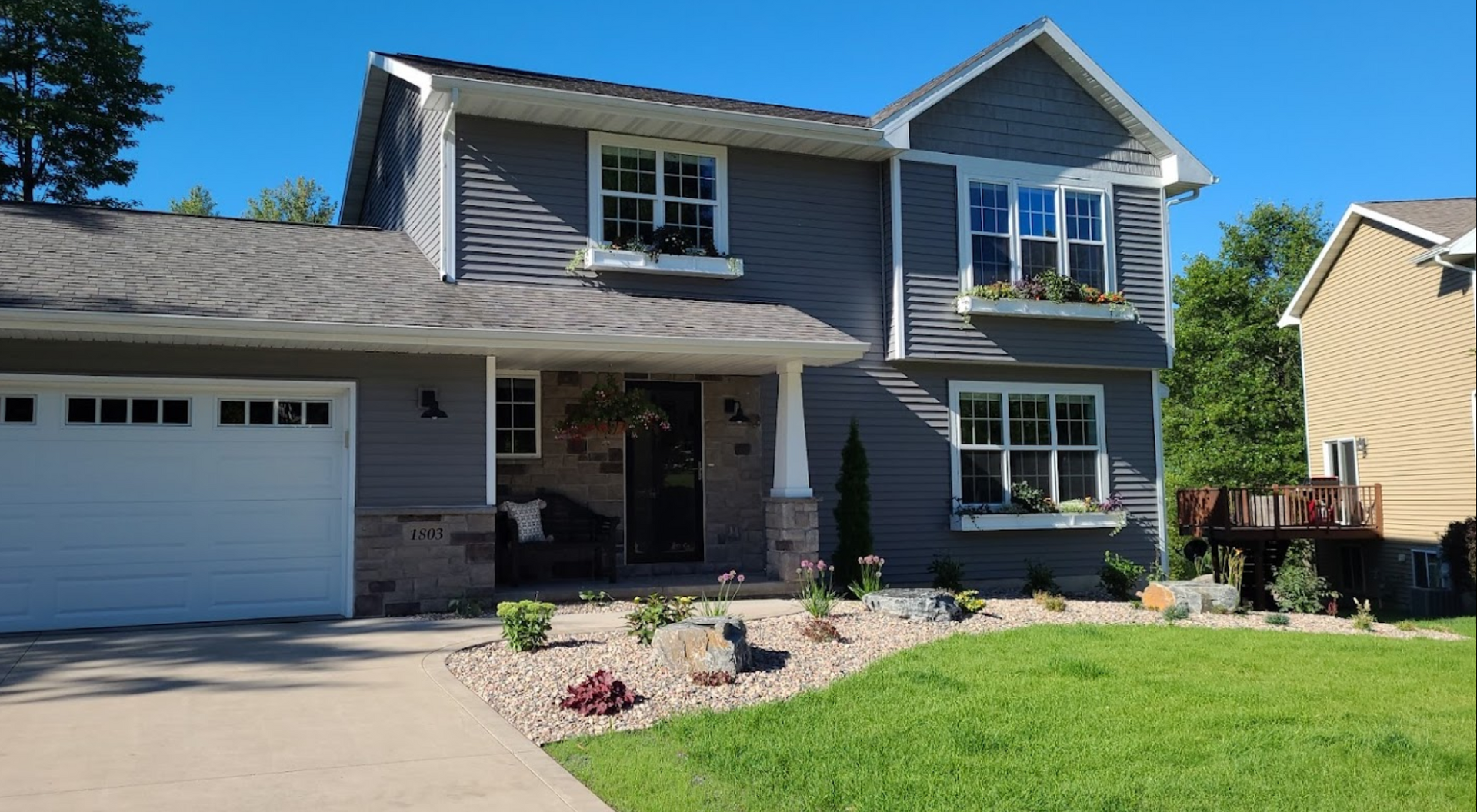 A large gray house with a white garage door
