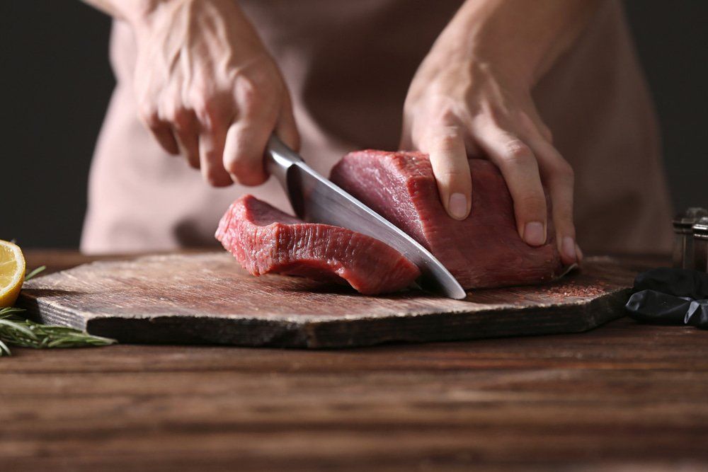 Butcher Cutting Meat — Butcher in Wauchope, NSW