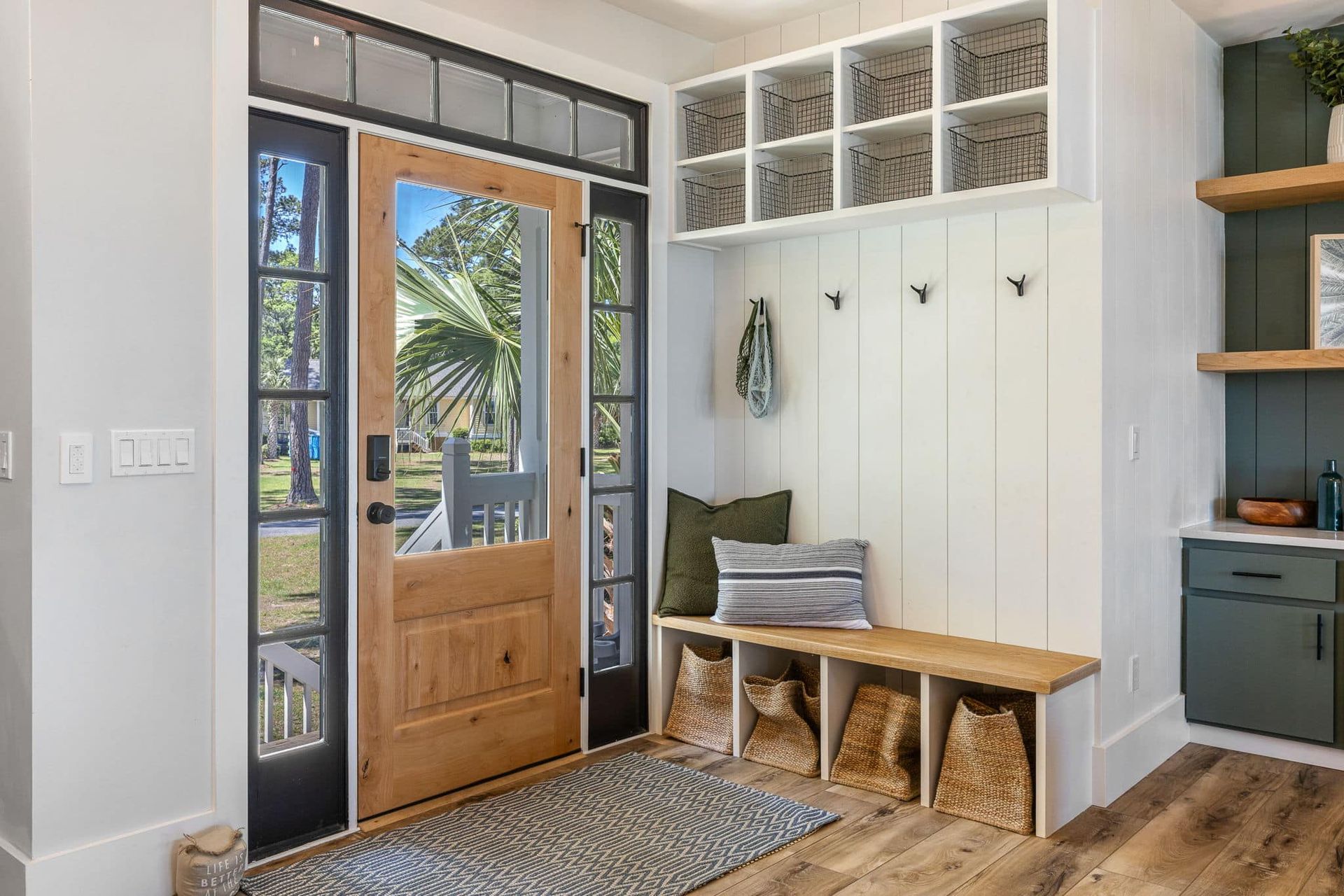 A hallway with a wooden door and a bench.