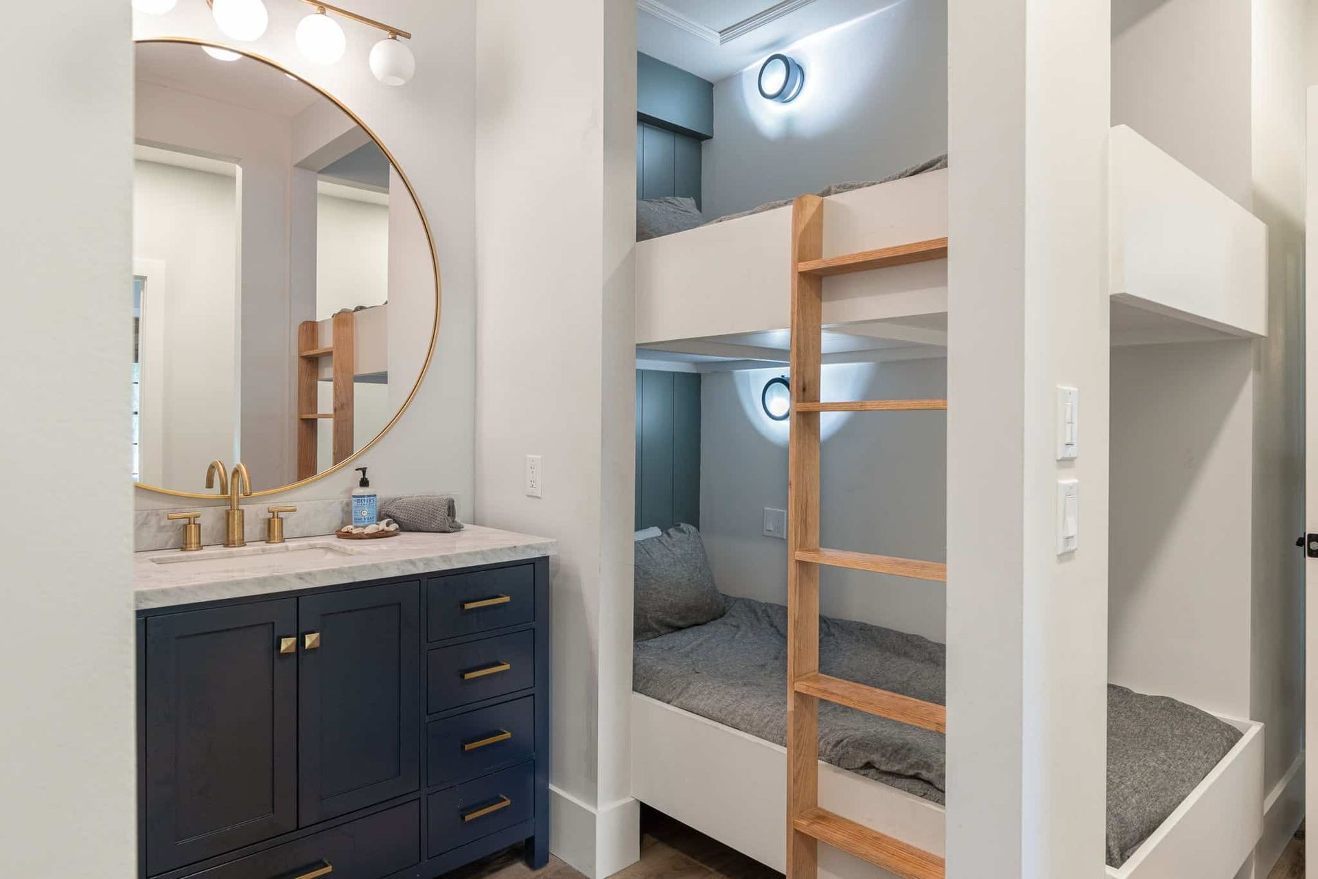 A bathroom with bunk beds and a sink.