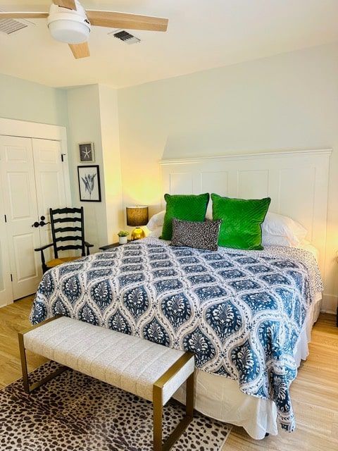 A bedroom with a large bed and a ceiling fan