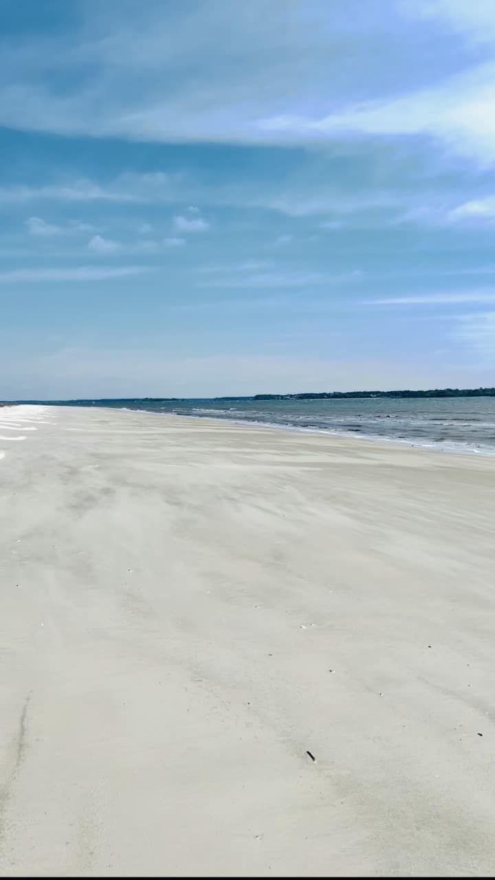 A large empty beach with a blue sky in the background.