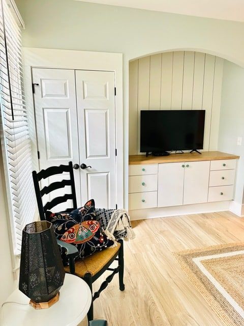 A living room with a chair and a flat screen tv