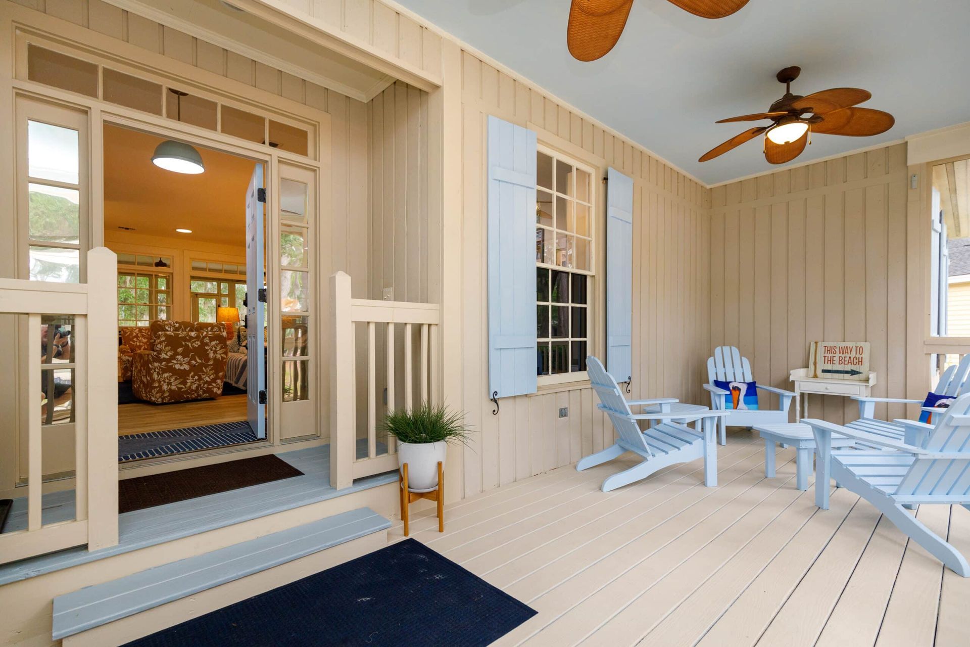 A porch with chairs and a ceiling fan