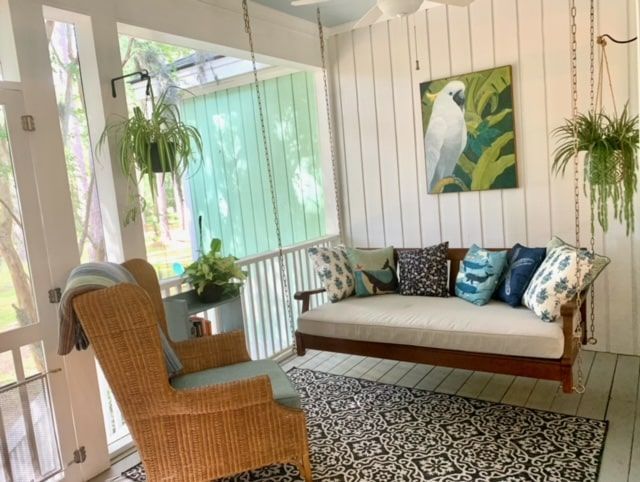 A porch with a swing and a chair