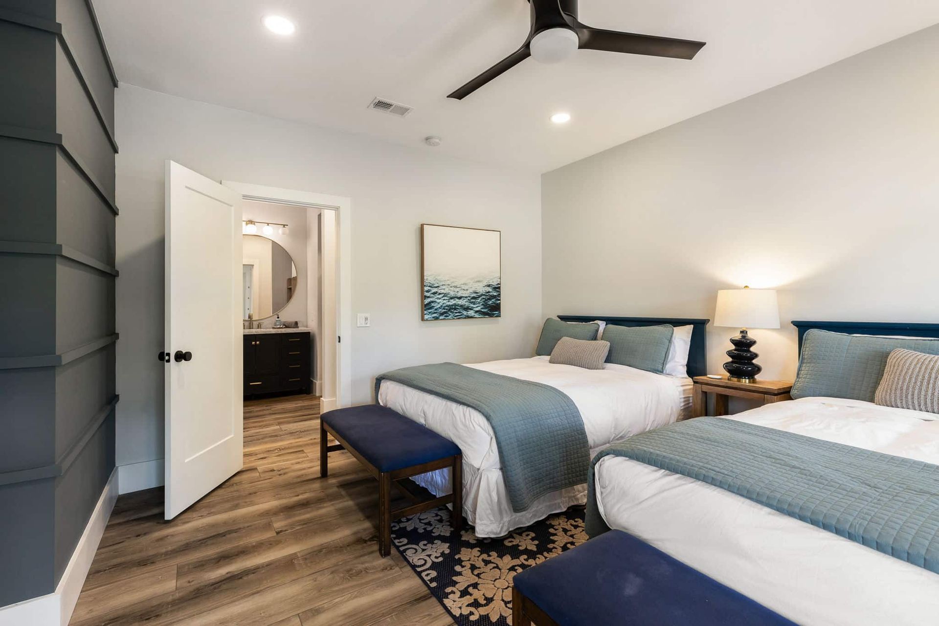A bedroom with two beds and a ceiling fan.