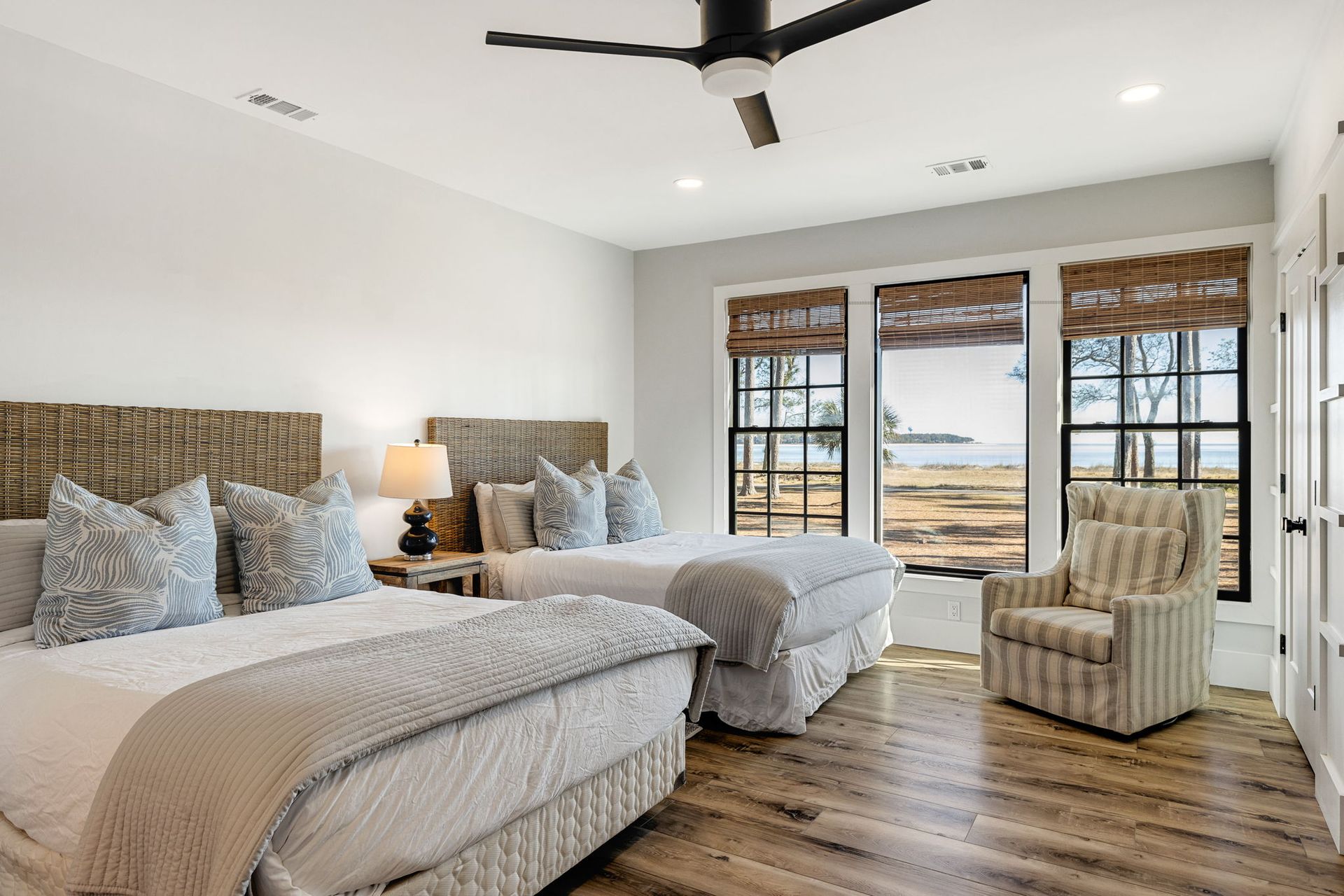A bedroom with two beds , a chair and a ceiling fan.