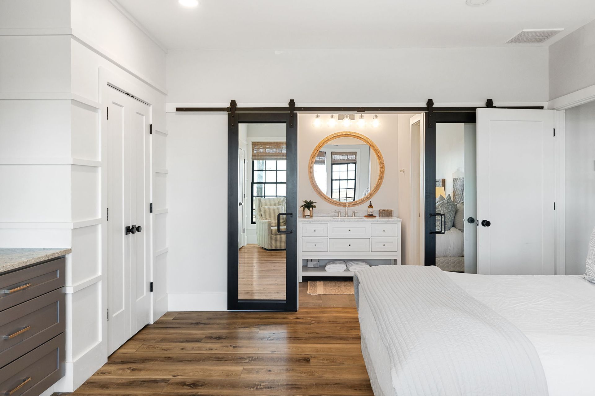 A bedroom with a sliding barn door leading to a bathroom.
