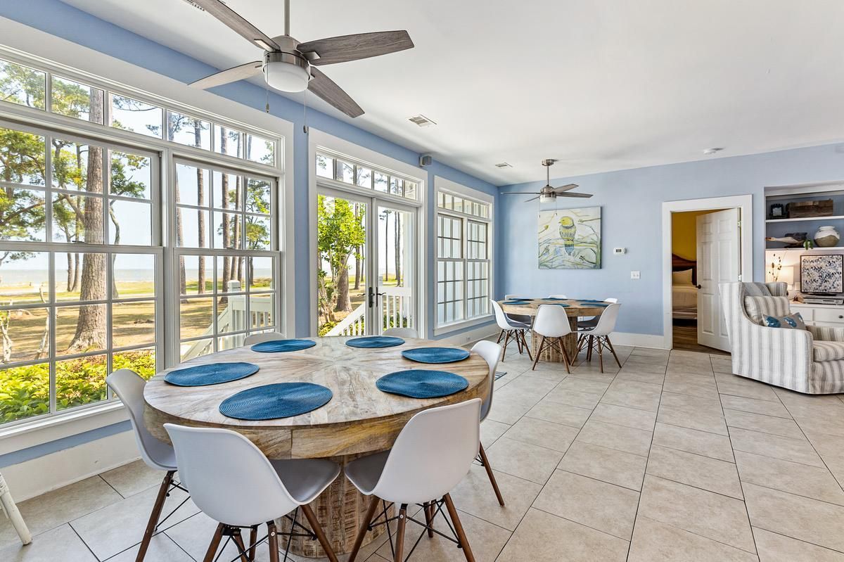 A dining room with a table and chairs and a ceiling fan.