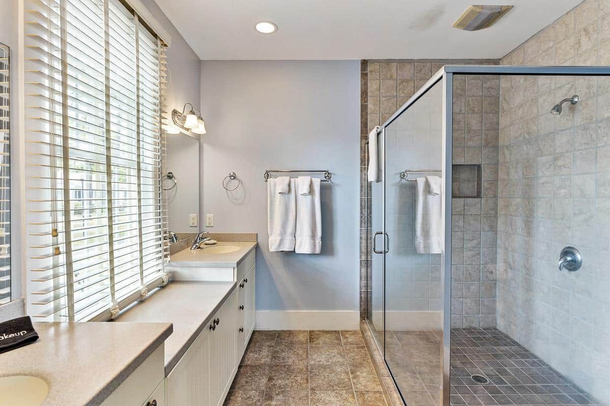 A bathroom with a walk in shower and a sink