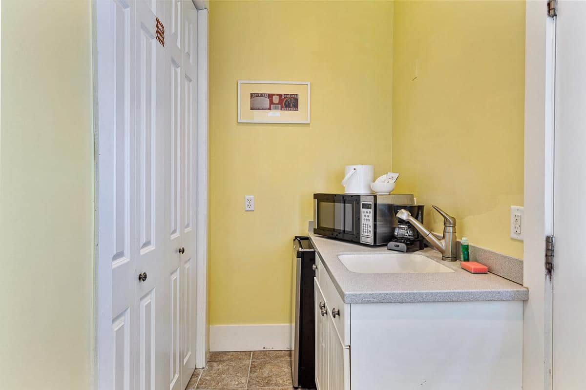 A kitchen with a sink , microwave , and coffee maker.