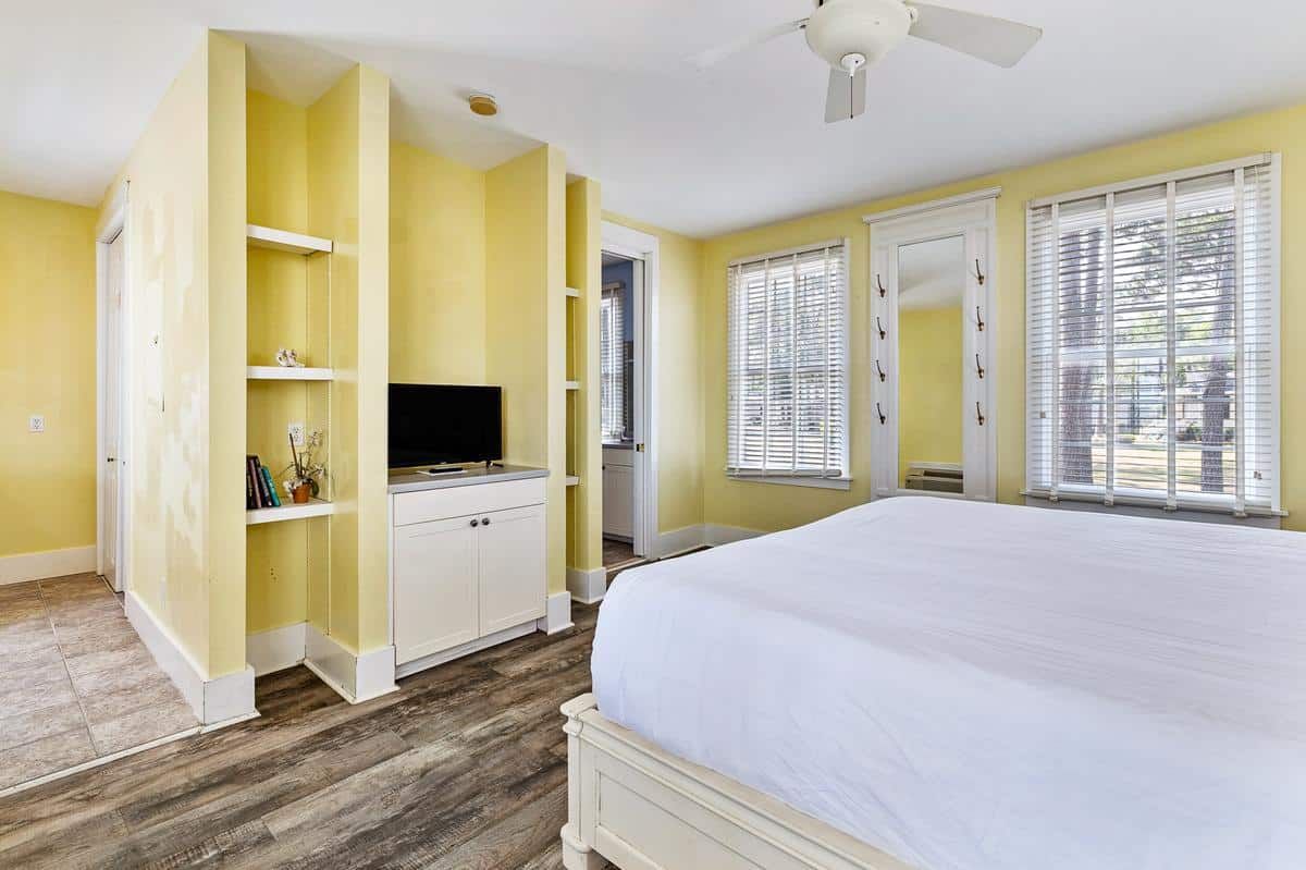 A bedroom with a king size bed and a flat screen tv.