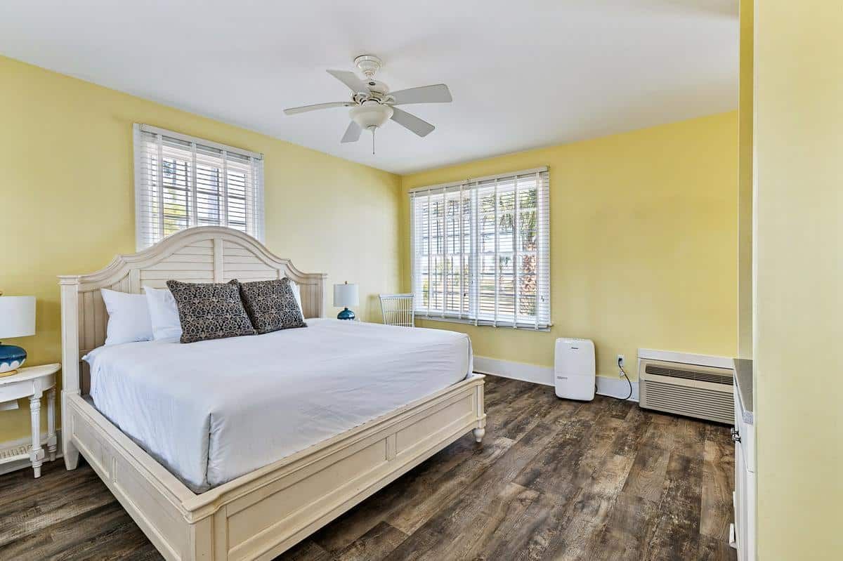 A bedroom with a king size bed and a ceiling fan.