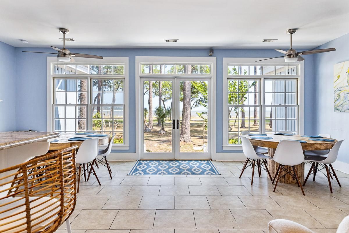 A living room with a dining table and chairs and a ceiling fan.