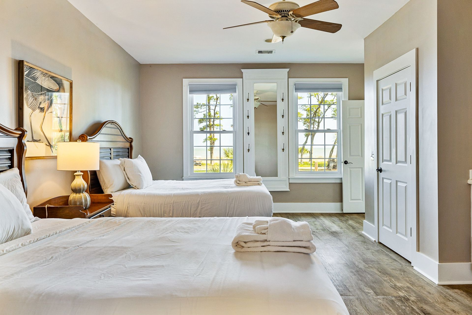 A bedroom with two beds and a ceiling fan.