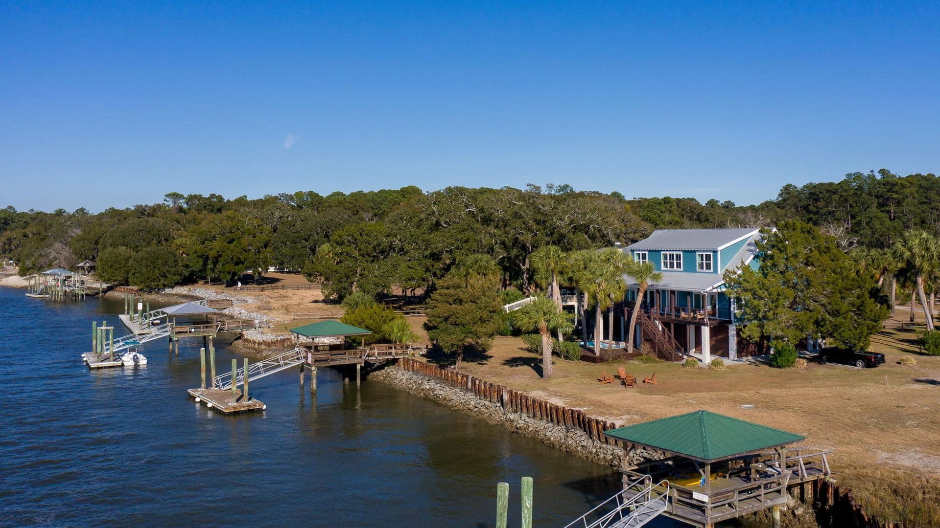 An aerial view of a house on a dock next to a body of water.
