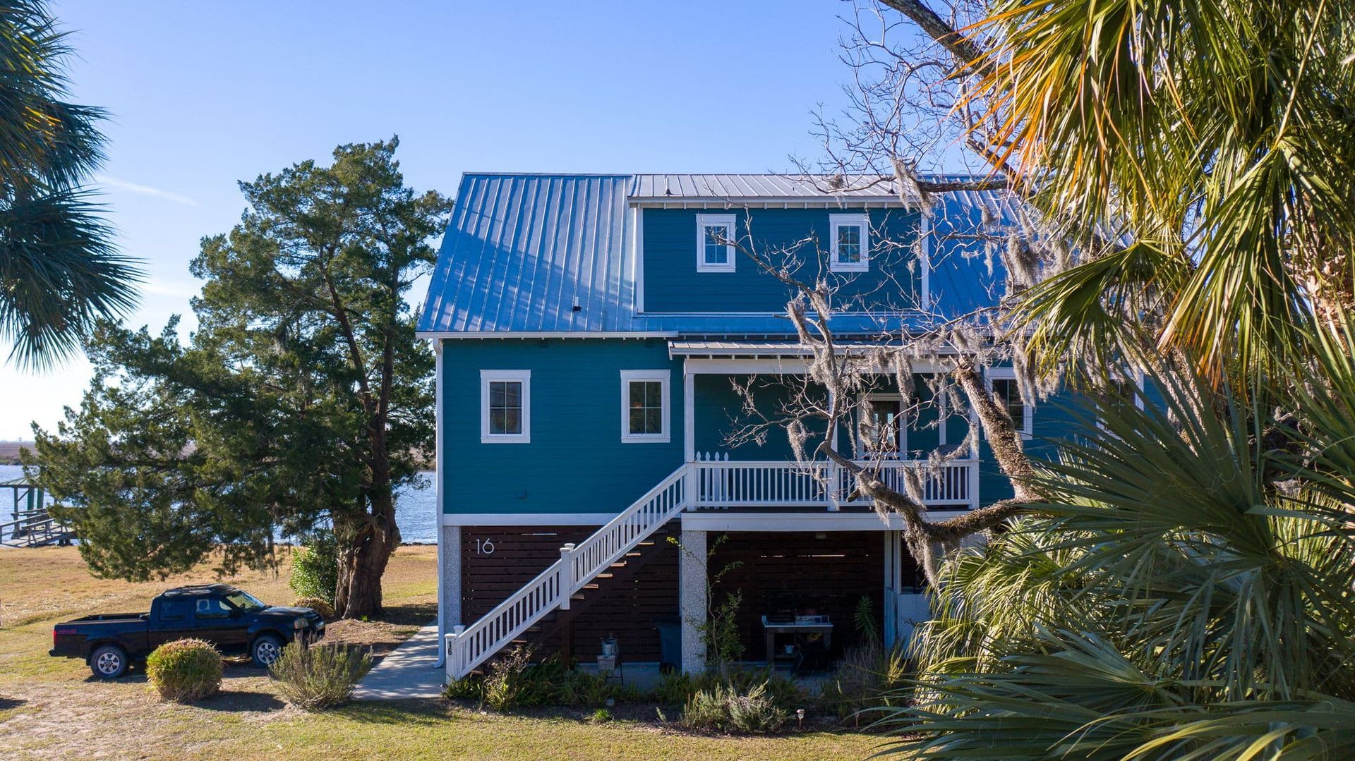 A blue house with a truck parked in front of it.
