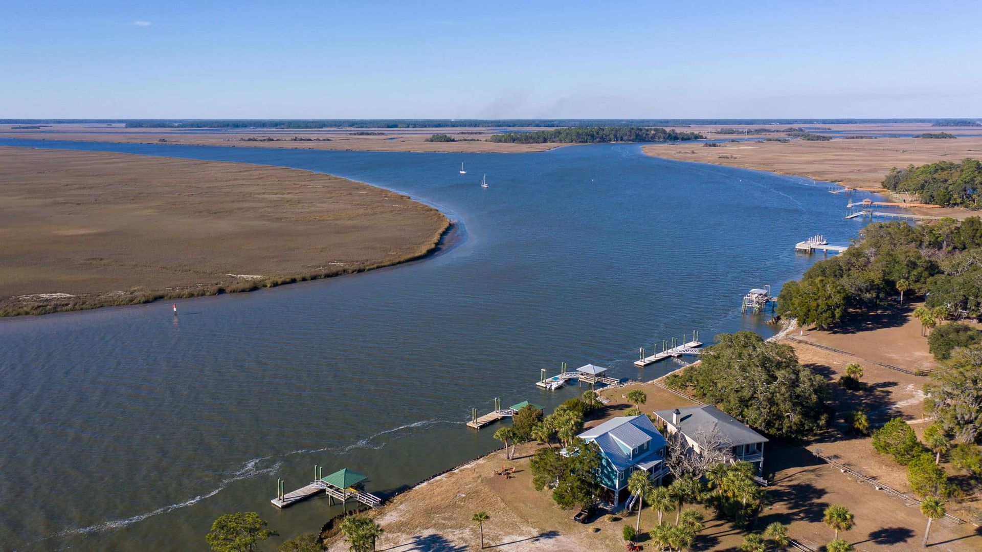 An aerial view of a large body of water with a house in the middle of it.