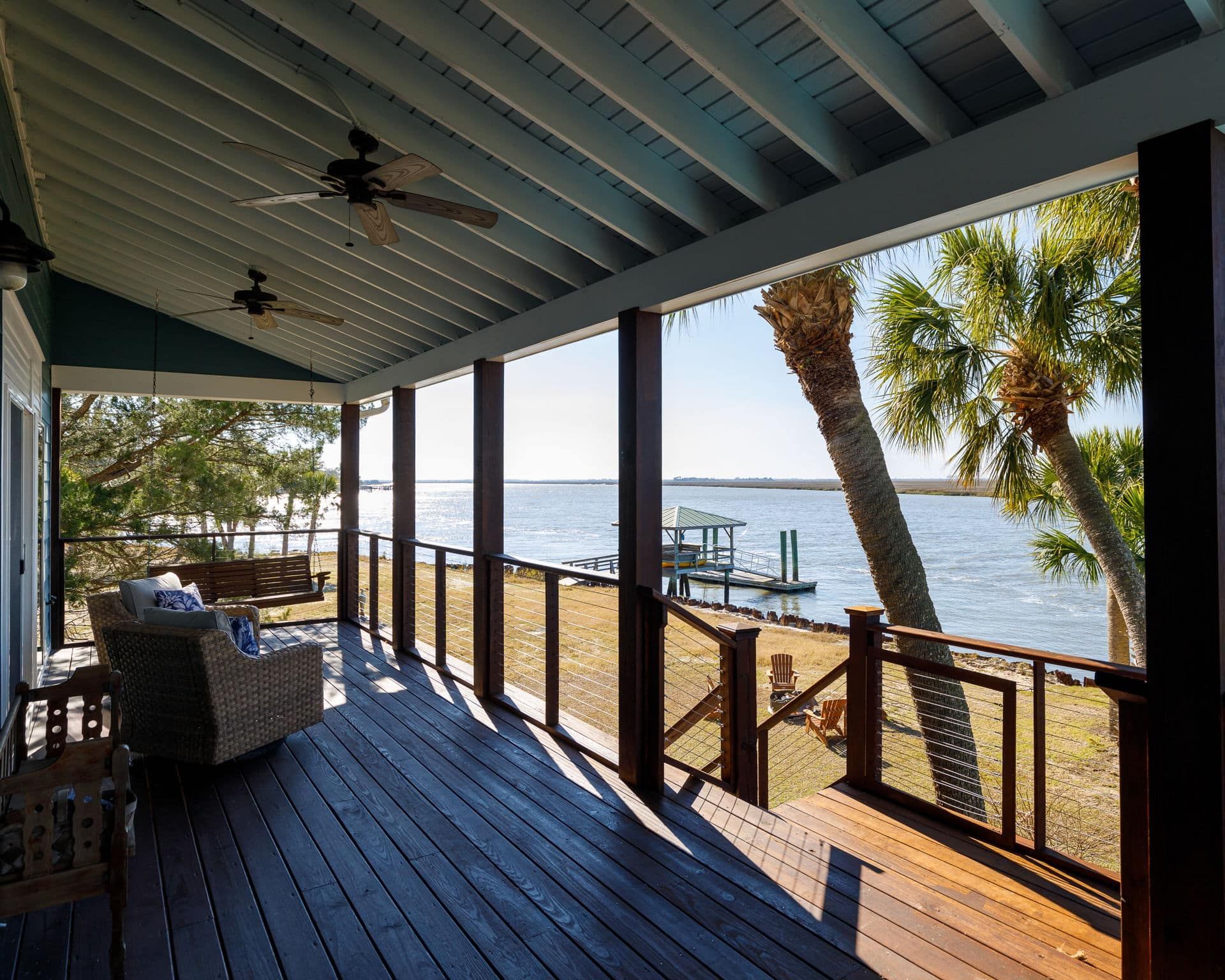 A large porch with a view of a body of water.