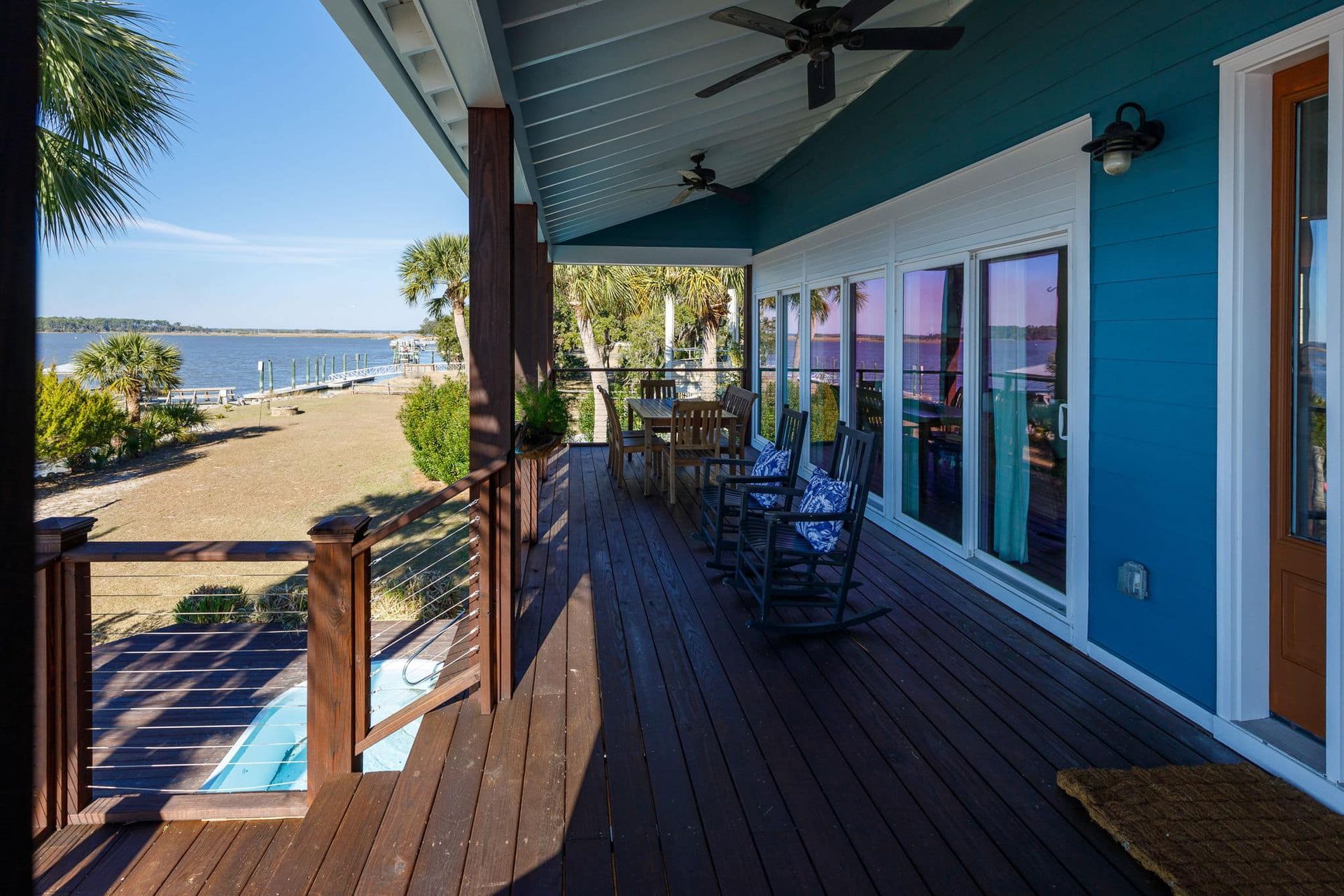 A large porch with rocking chairs and a view of the ocean.