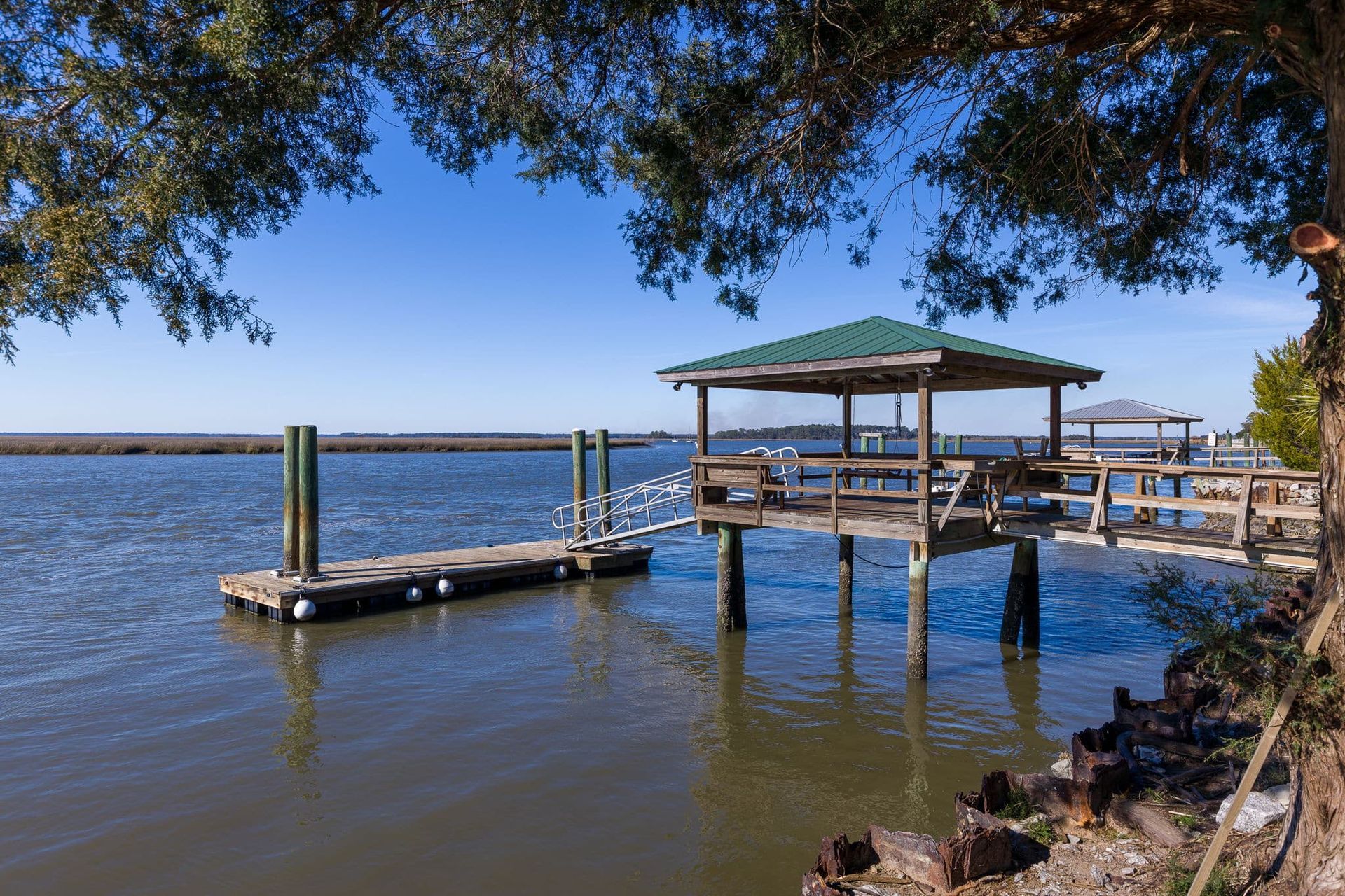 A dock with a gazebo on top of it overlooking a body of water.
