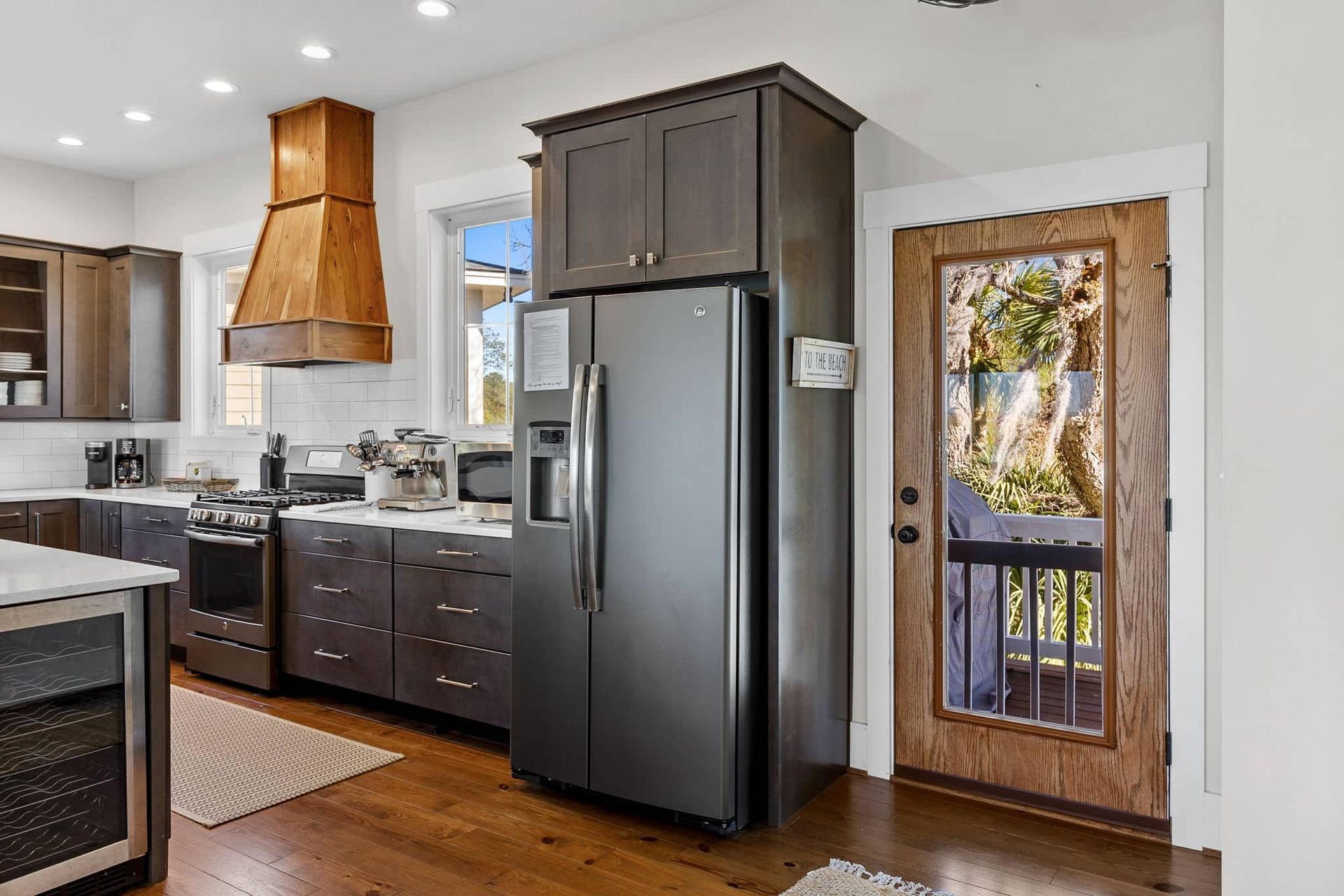 A kitchen with a stainless steel refrigerator and a wooden door.