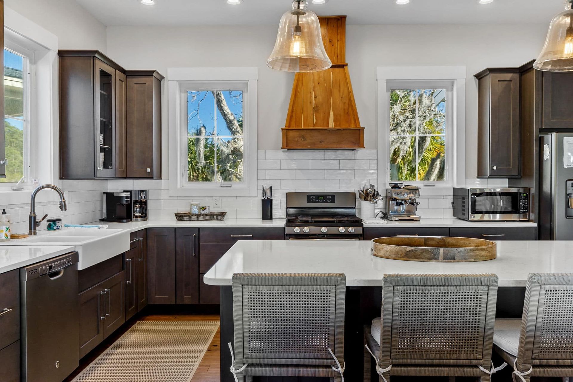 A kitchen with a large island , stove , refrigerator , sink and dishwasher.