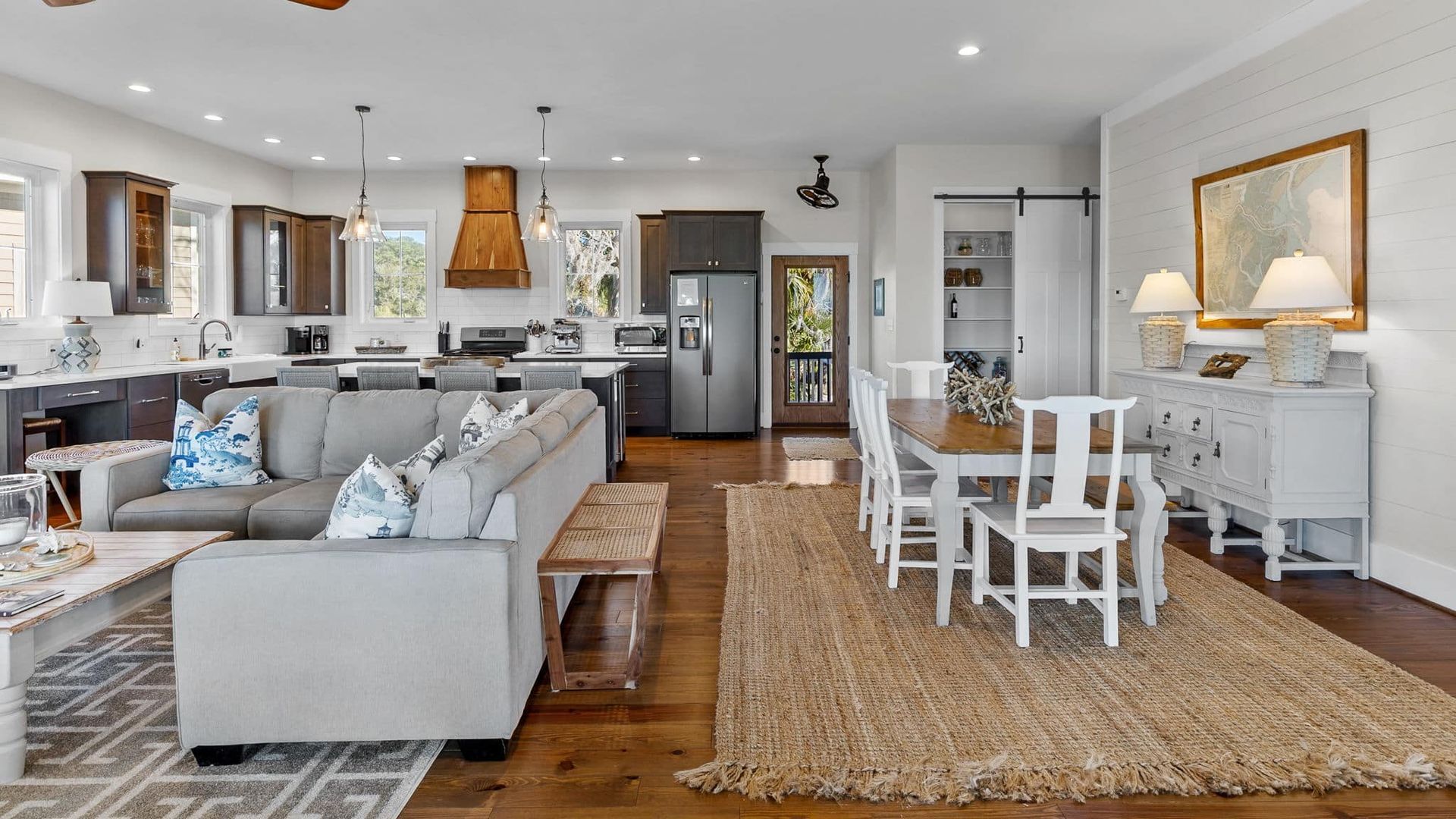 A living room with a couch , table , chairs and a rug.
