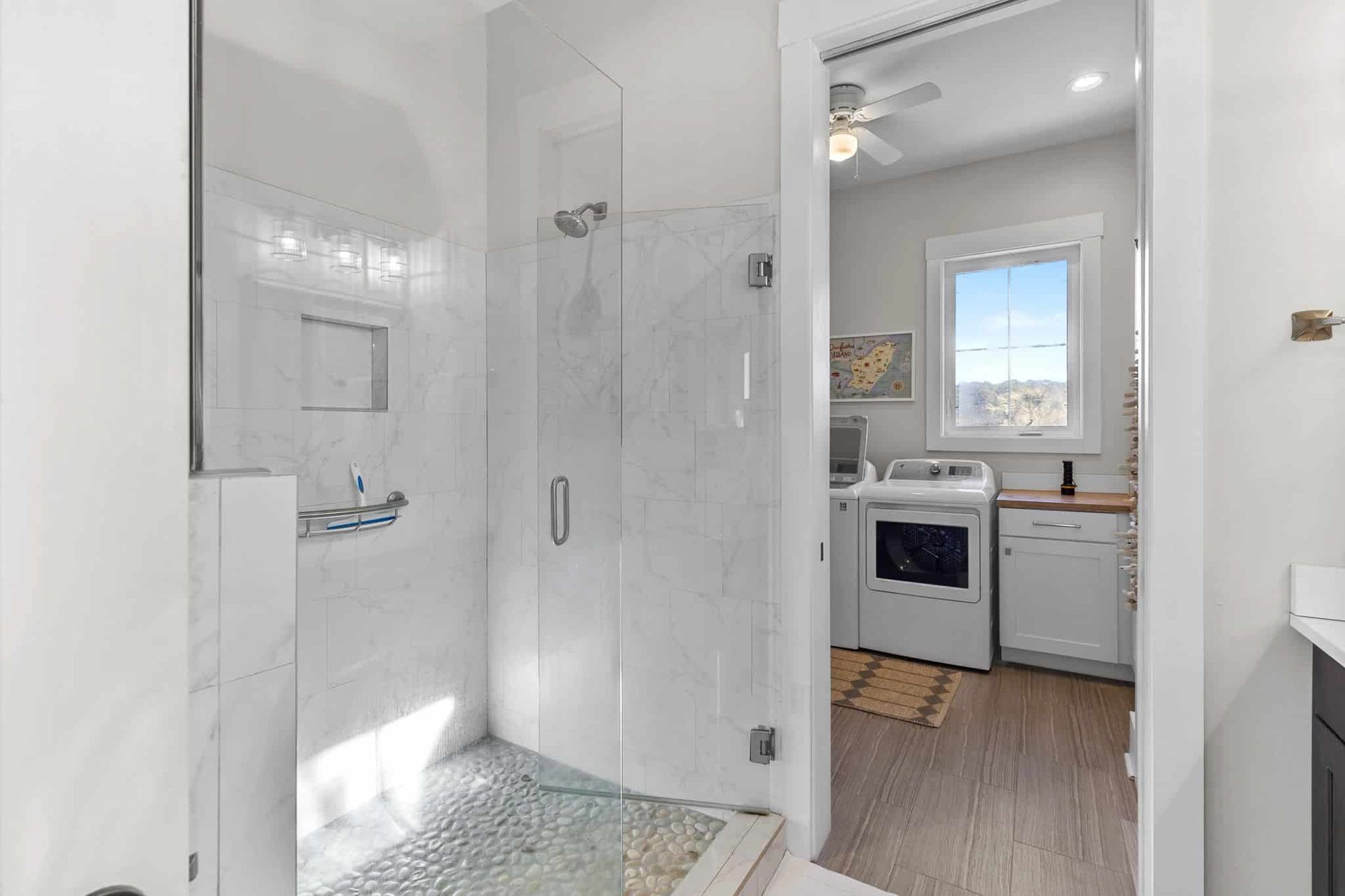 A bathroom with a walk in shower and a laundry room.