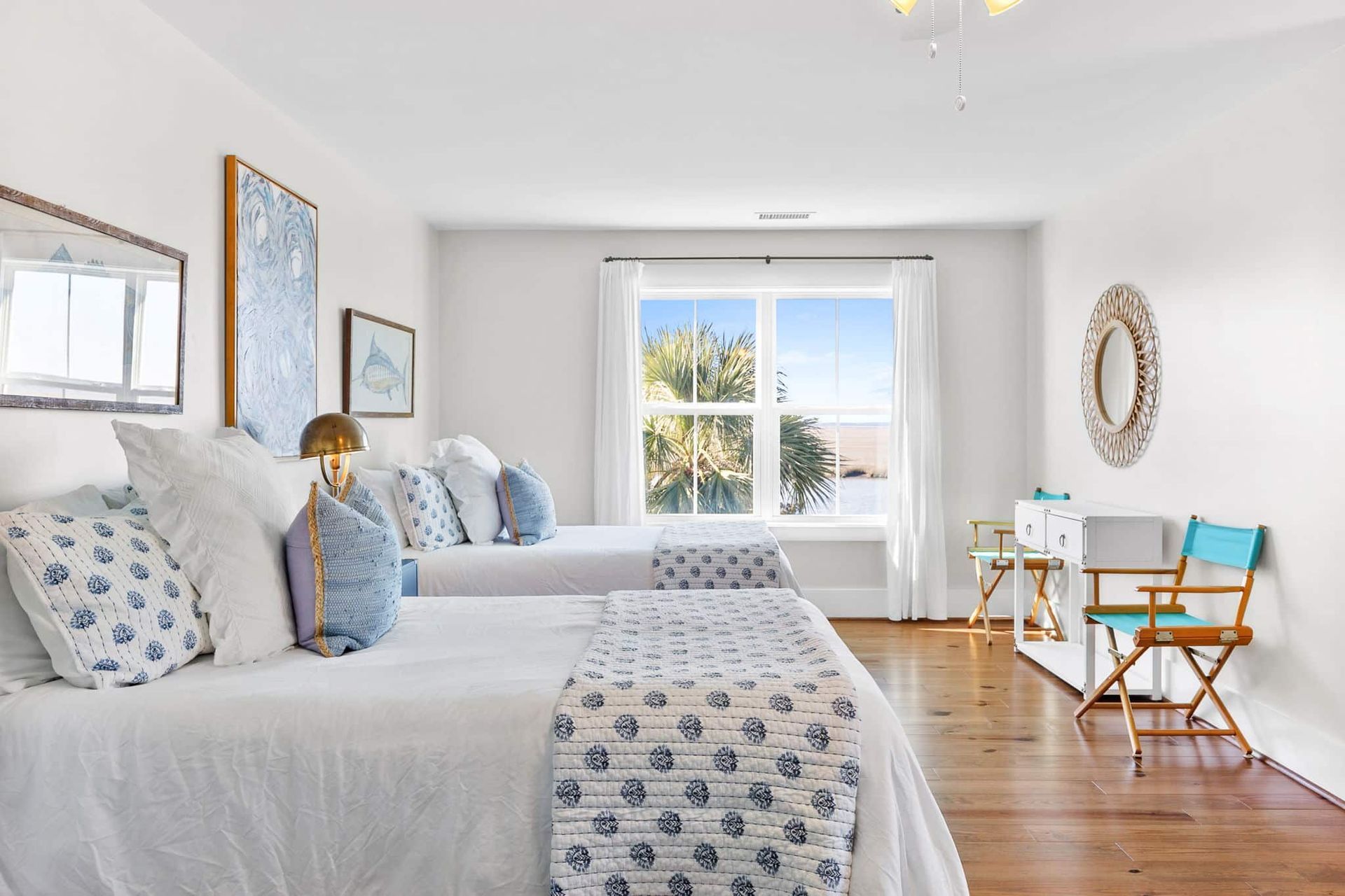 A bedroom with two beds , a desk and a large window.