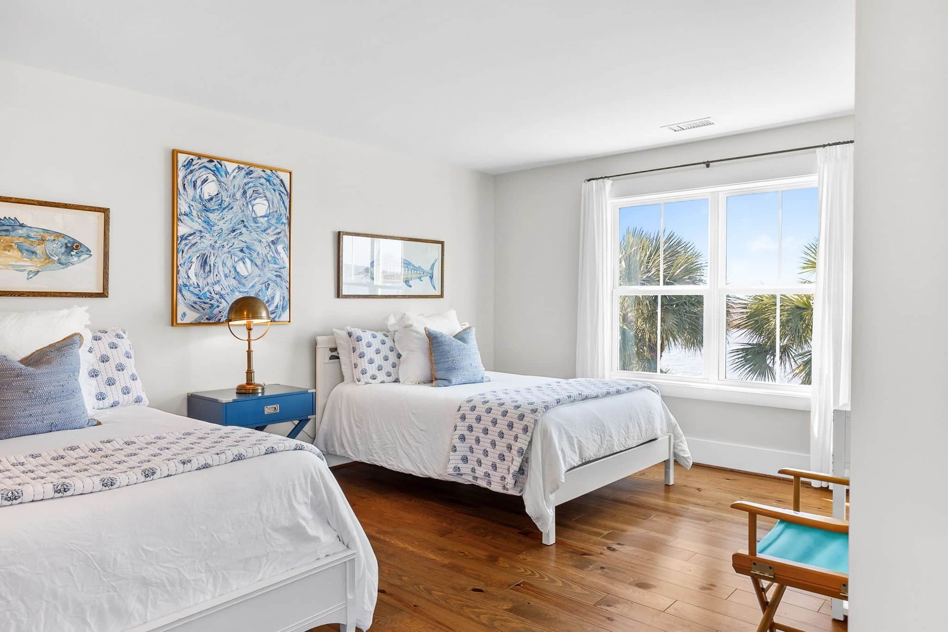 A bedroom with two beds , a chair and a window.