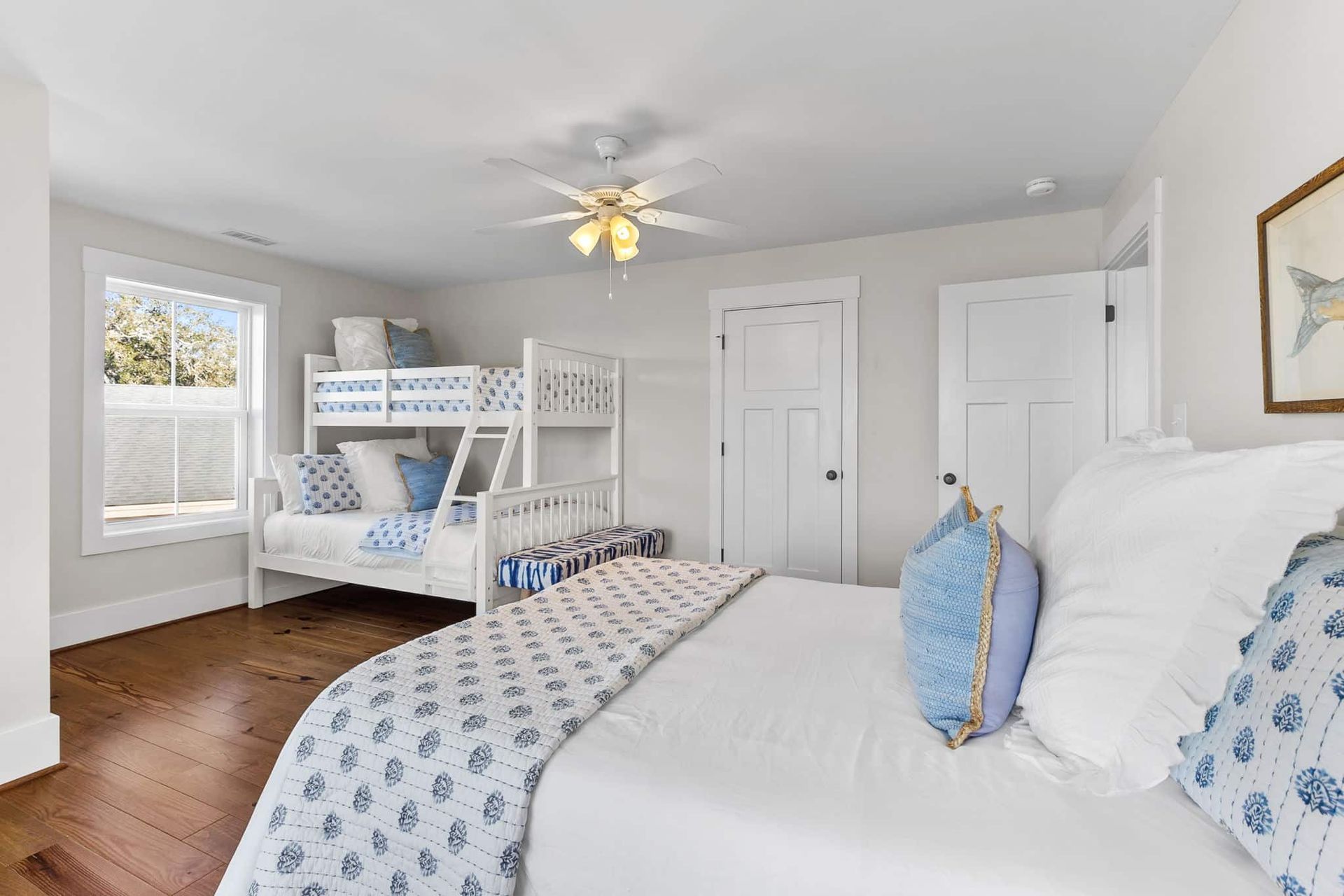 A bedroom with a bed , bunk beds , and a ceiling fan.