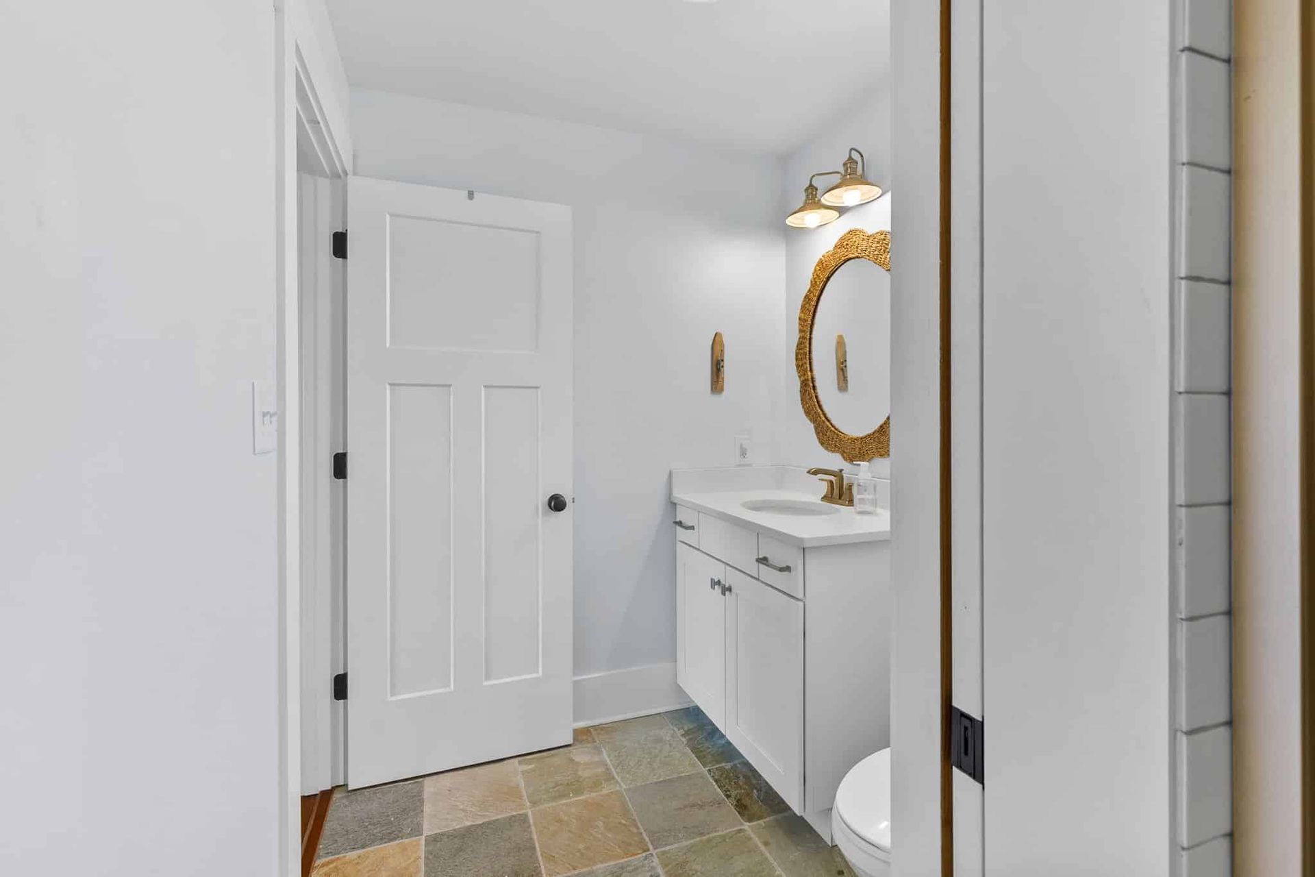 A bathroom with a sink , toilet and mirror.