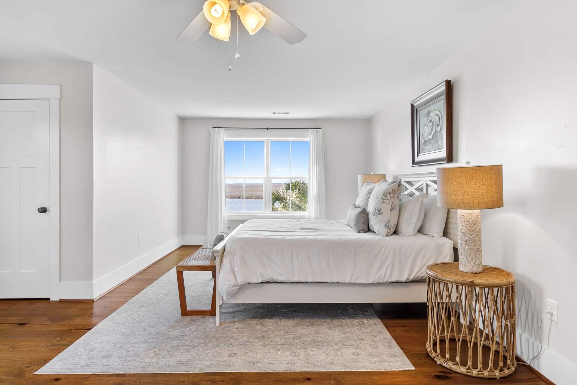 A bedroom with a large bed and a ceiling fan.