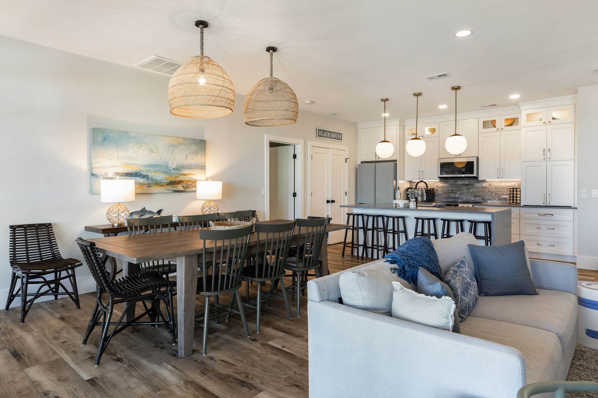 A living room with a couch , table , chairs and a kitchen.