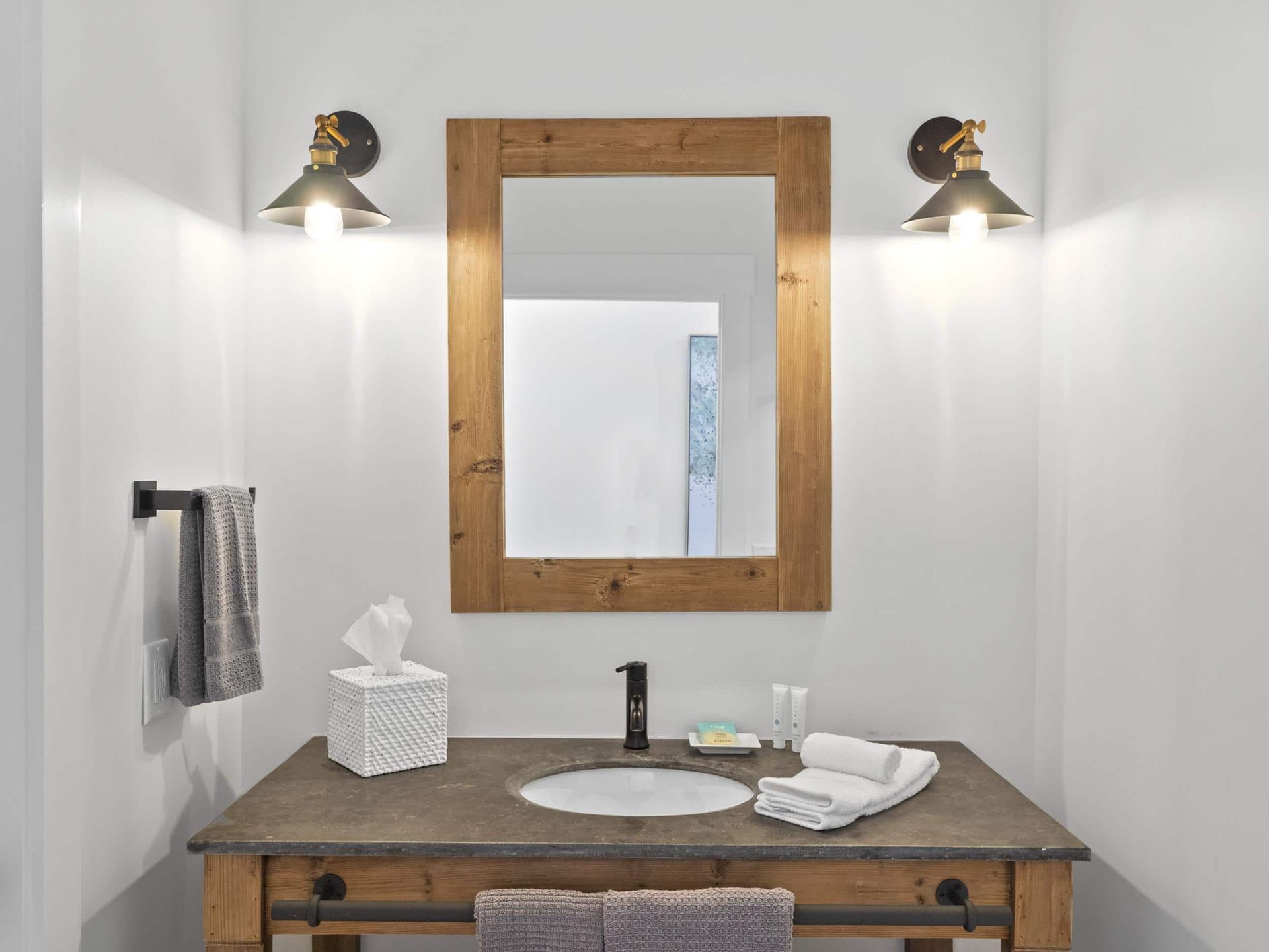 A bathroom with a sink , mirror and towels on the counter.