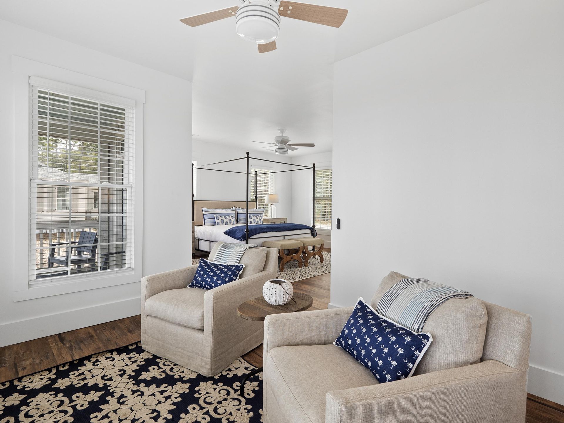 A living room with two chairs and a ceiling fan.
