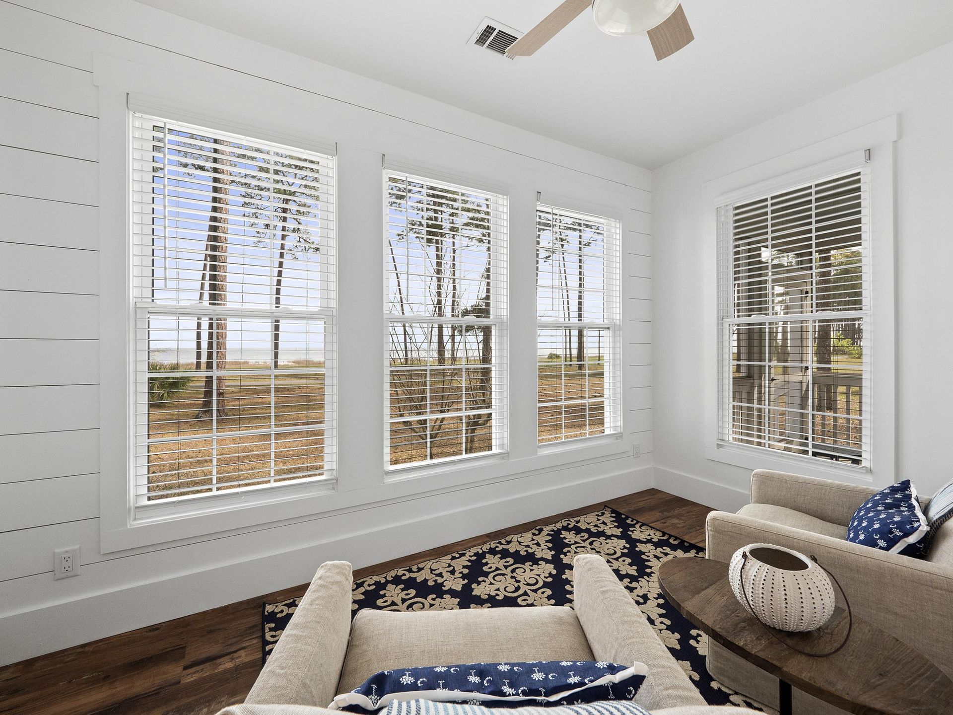 A living room with a chair and a ceiling fan