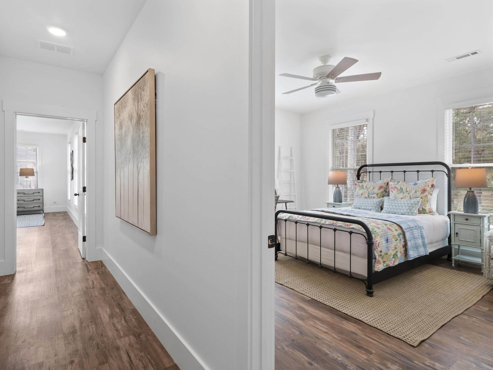 A bedroom with a bed , nightstands , lamps and a ceiling fan.