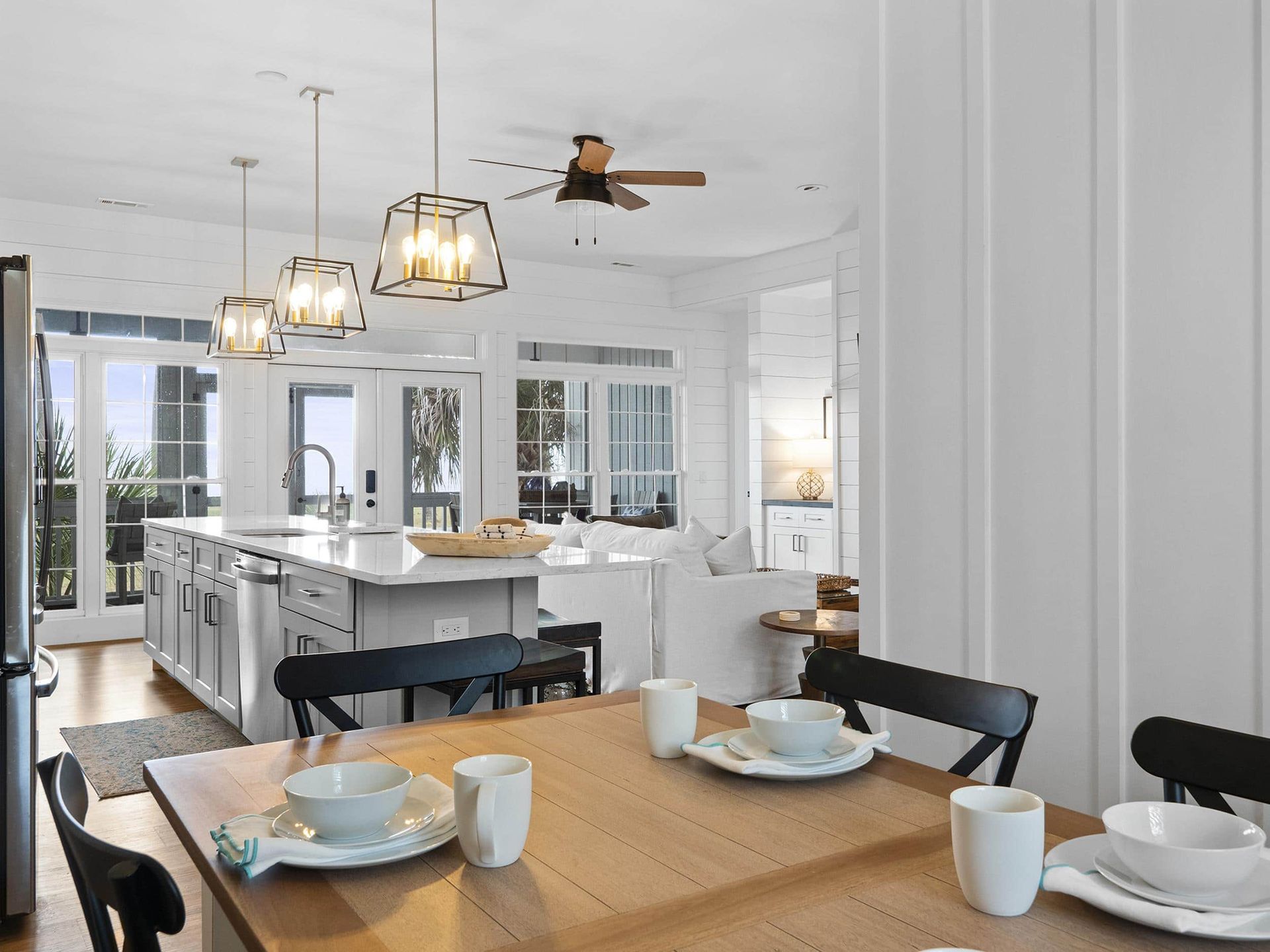 A dining room table with plates and bowls on it in a kitchen.