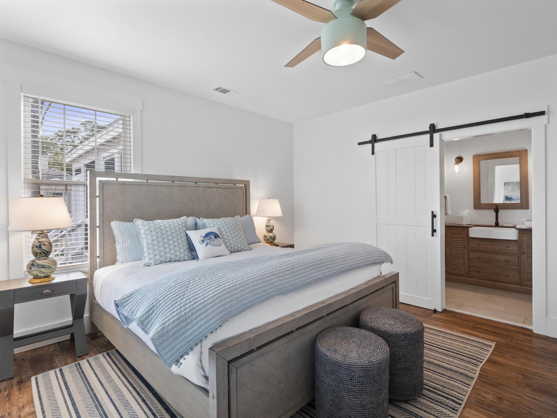 A bedroom with a king size bed and a ceiling fan.