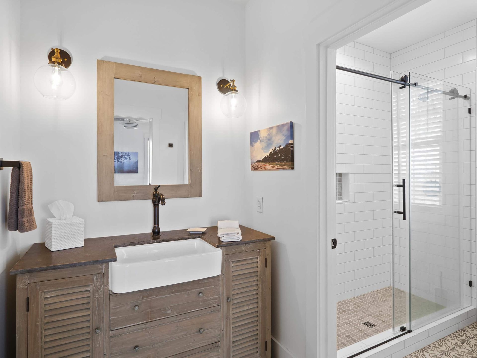 A bathroom with a sink , mirror , and walk in shower.