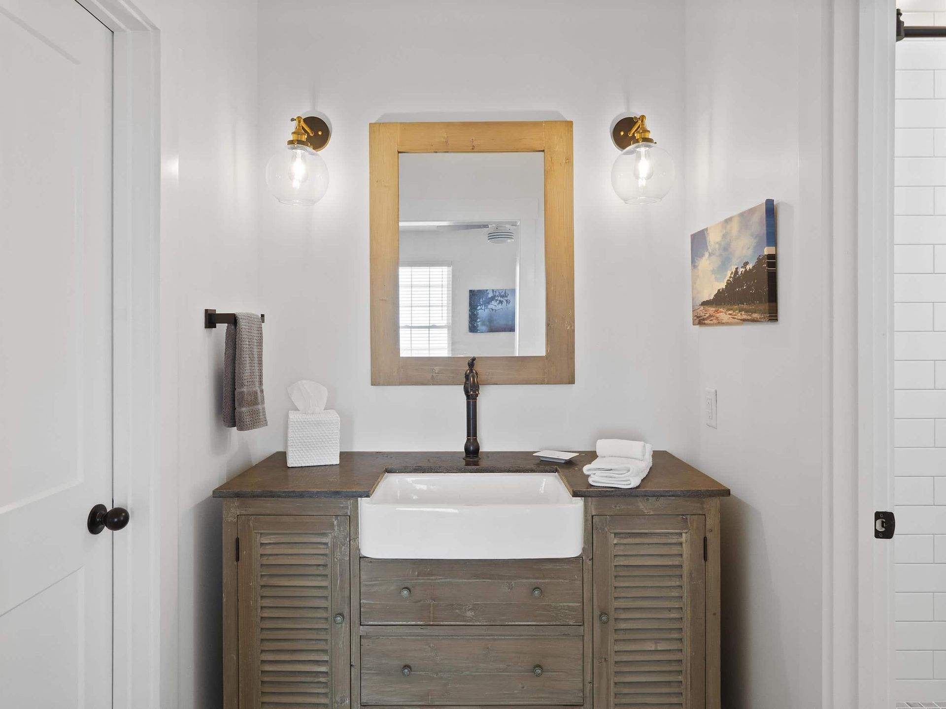 A bathroom with a sink , mirror and cabinets.