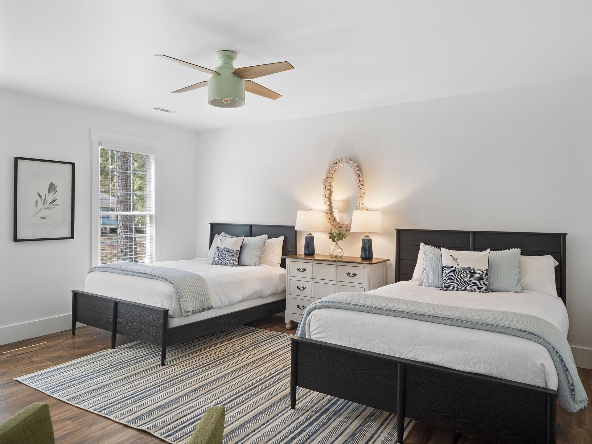 A bedroom with two beds and a ceiling fan.