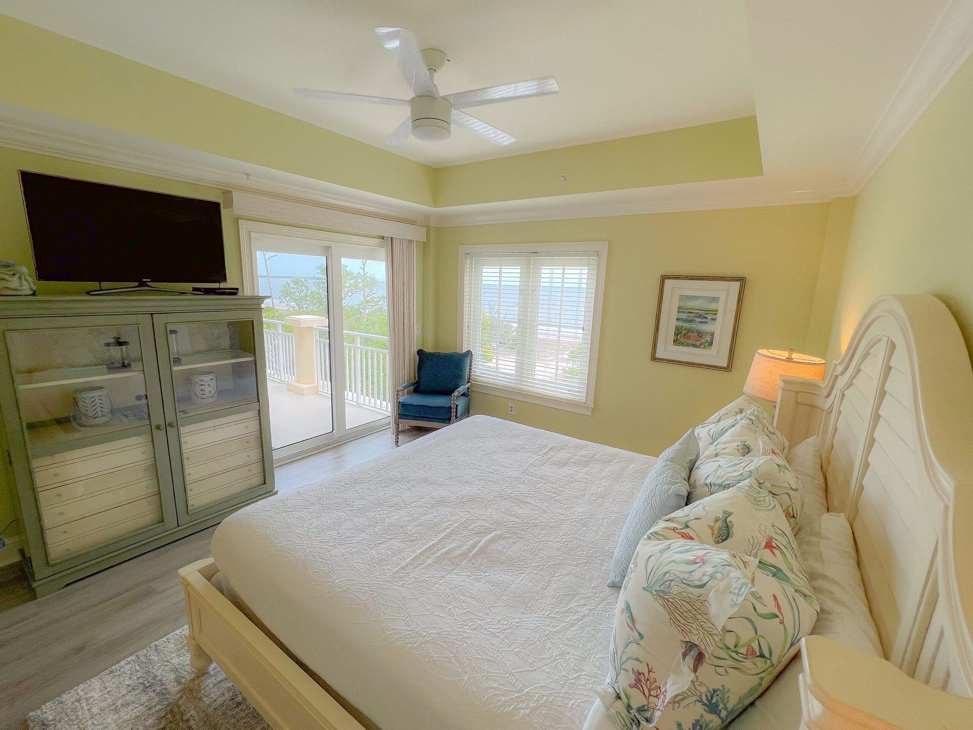 A bedroom with a king size bed , television , and sliding glass doors.