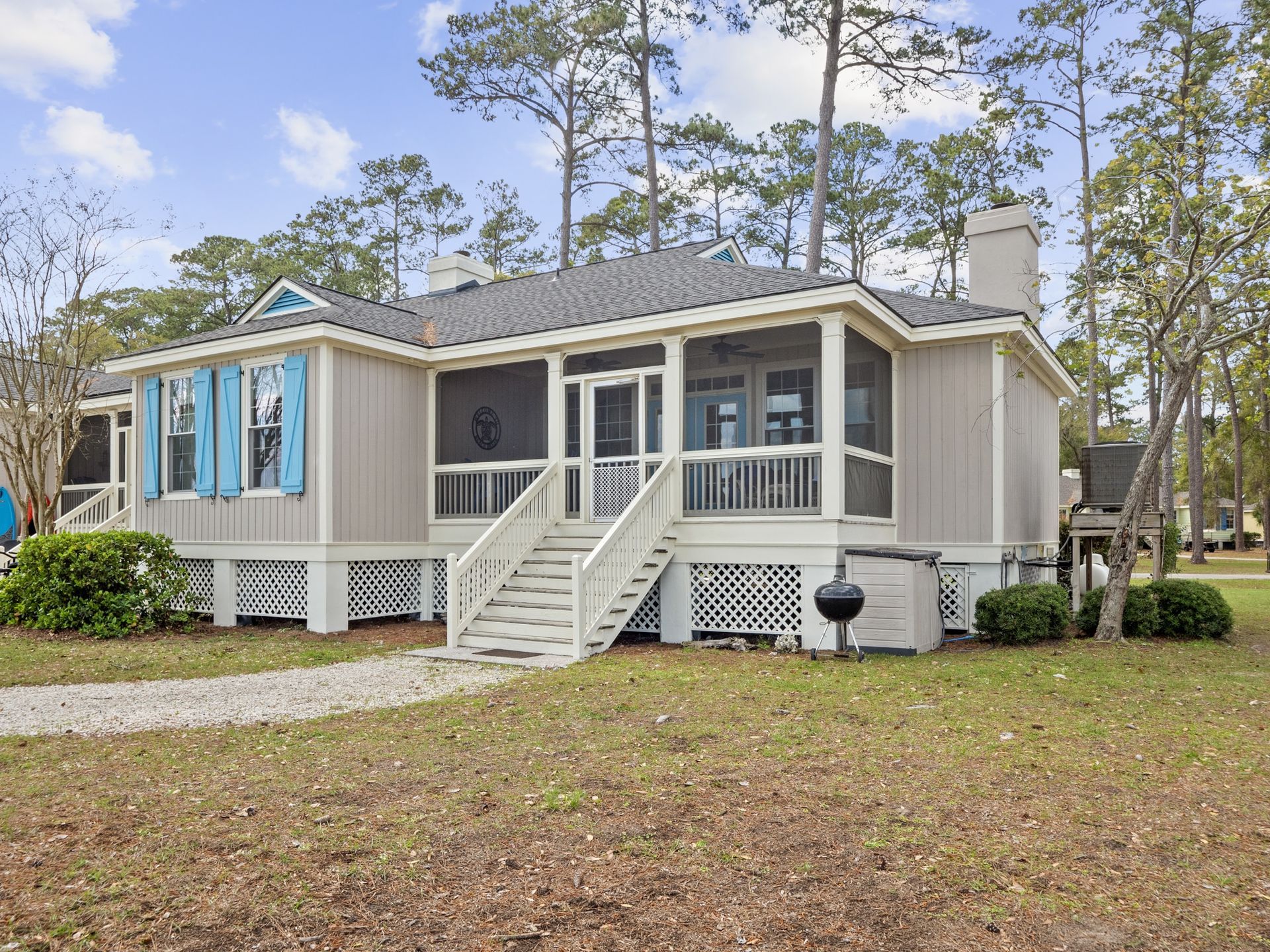 A small house with a screened in porch and stairs