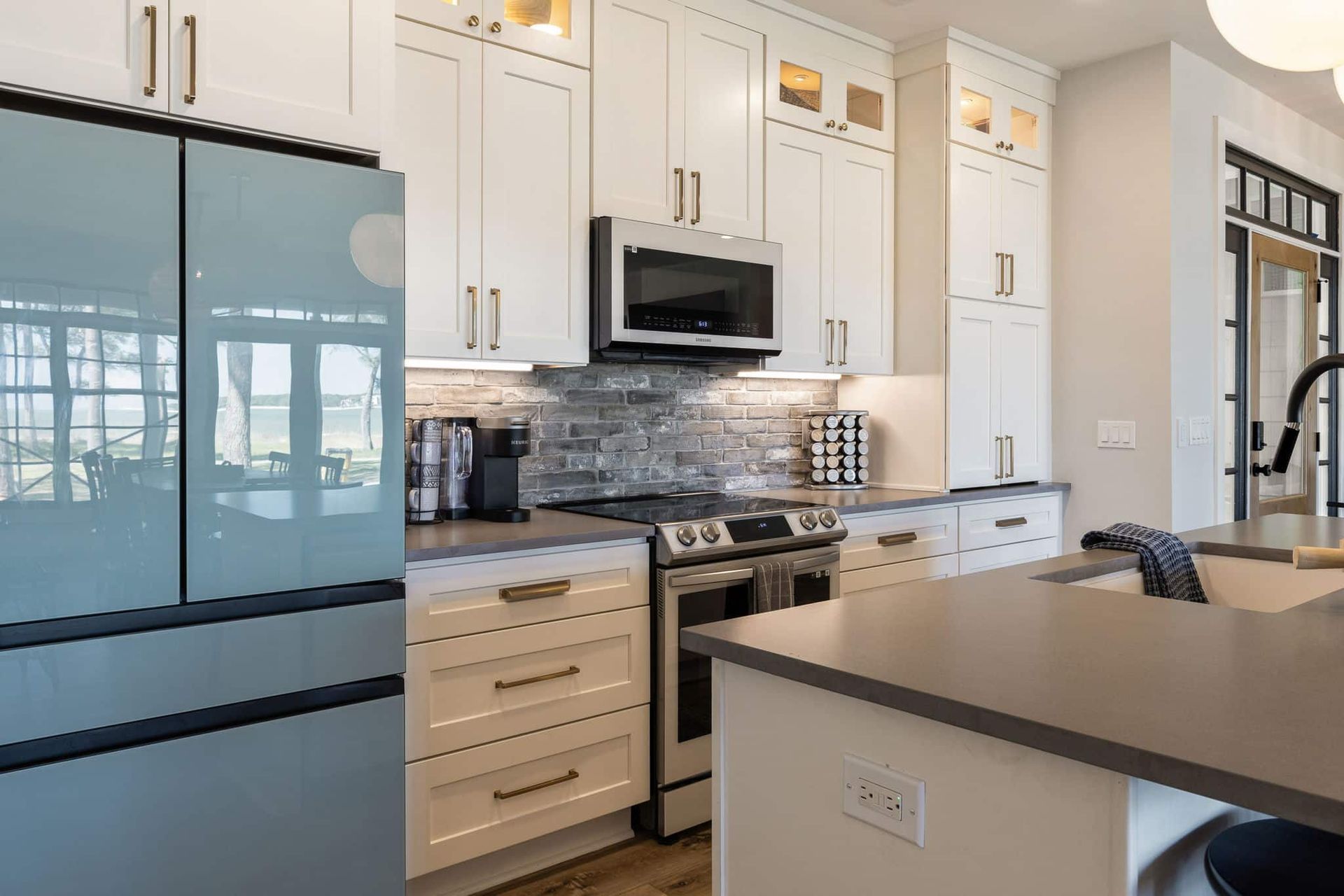 A kitchen with white cabinets , stainless steel appliances , and a blue refrigerator.