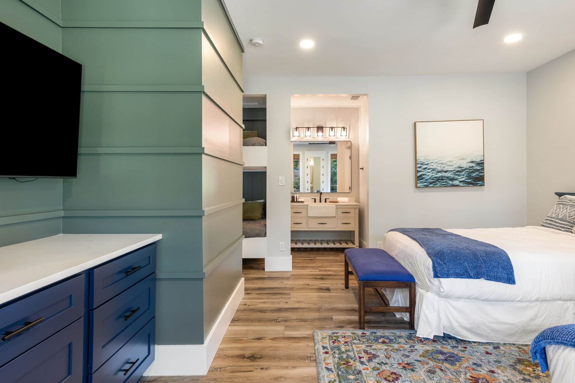 A bedroom with two beds , a dresser and a flat screen tv.
