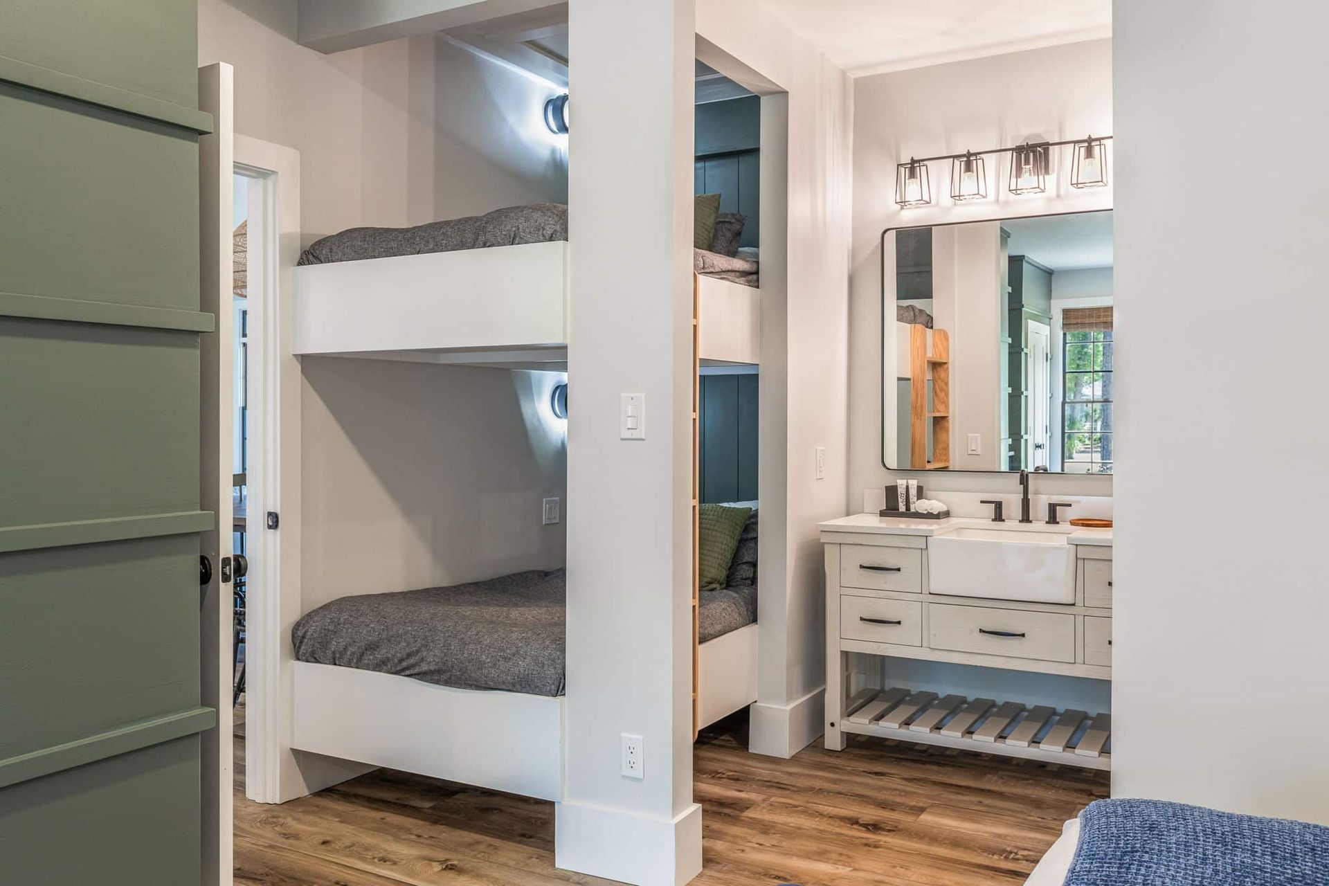A bedroom with bunk beds and a bathroom with a sink.